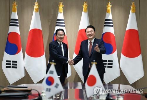 밝게 웃으며 악수하는 한일 정상