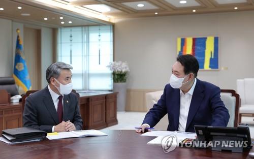 La foto, proporcionada por la oficina presidencial de Corea del Sur, muestra al presidente, Yoon Suk-yeol (dcha.), recibiendo un informe del ministro de Defensa, Lee Jong-sup, el 22 de julio de 2022, en la oficina, en Seúl. (Prohibida su reventa y archivo)