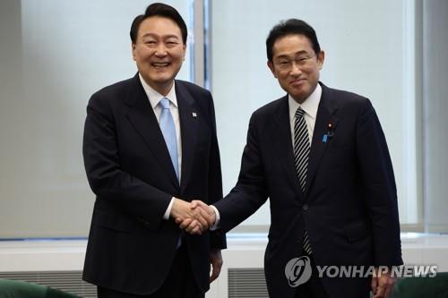 El presidente surcoreano, Yoon Suk-yeol (izda.), y el primer ministro japonés, Fumio Kishida, se estrechan la mano antes de su cumbre celebrada, el 21 de septiembre de 2022 (hora local), en Nueva York, EE. UU.