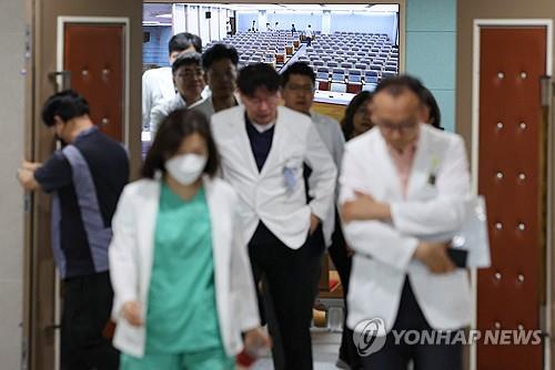 Los profesores de medicina de la Universidad Nacional de Seúl salen de un auditorio, luego de llevar a cabo una reunión general, el 20 de junio de 2024. 