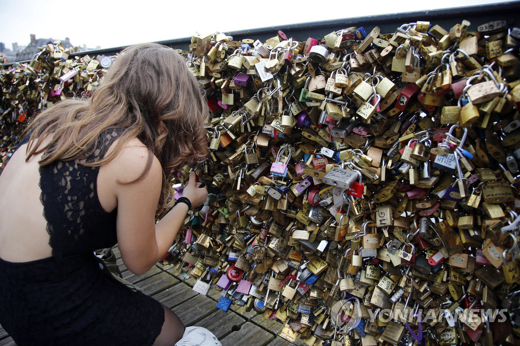한 관광객이 프랑스 파리 '퐁데자르' 다리에 묶인 자물쇠를 살피는 모습(AP=연합뉴스 자료사진)