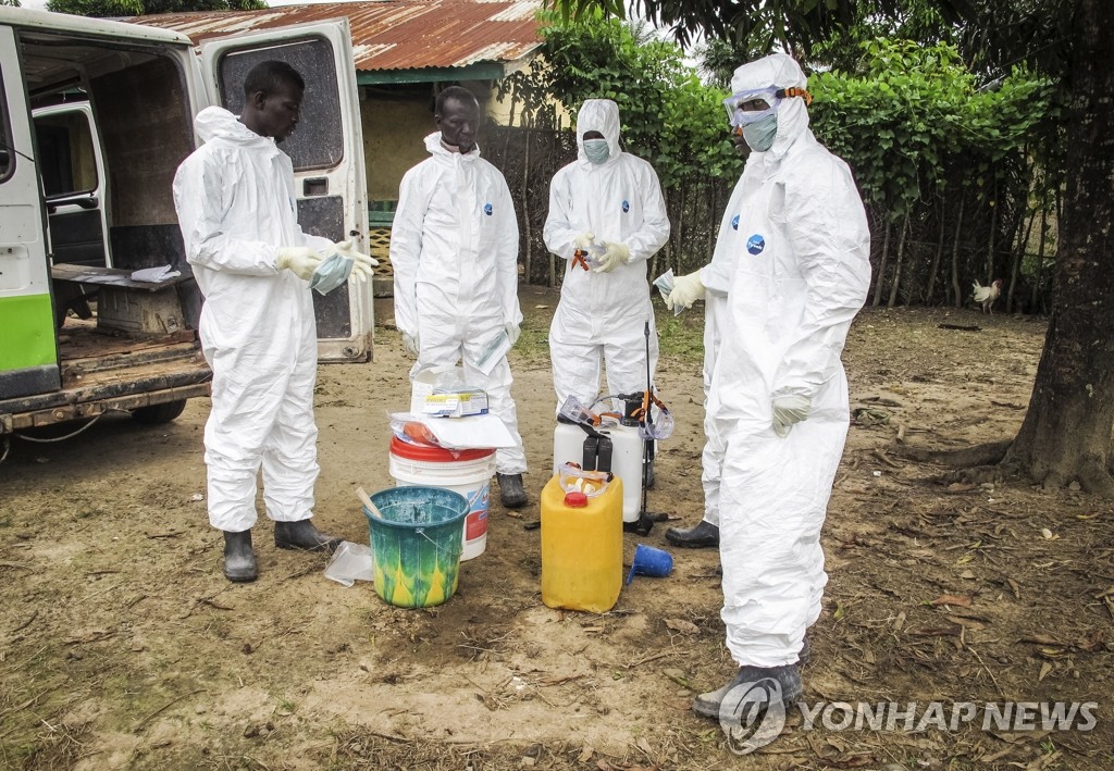 21일(현지시간) 시에라리온 보건당국 관계자들이 에볼라에 의해 죽은 주민의 집을 수색하기 위해 보호장비를 착용하고 있다. (AP=연합뉴스)
