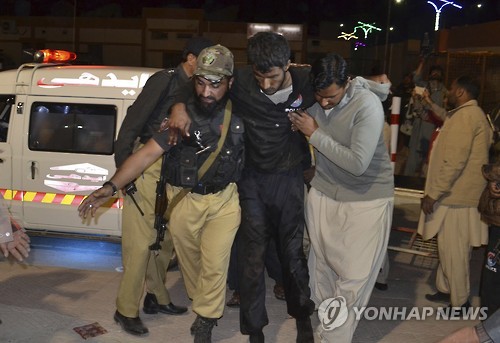 24일 파키스탄 퀘타의 한 병원에서 경찰관과 자원봉사자가 경찰대학 테러로 다친 부상자를 옮기고 있다.[AP=연합뉴스]
