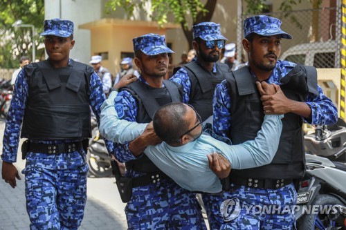 지난 15일 몰디브 수도 말레에서 경찰들이 국회에 들어가려던 야당 인사를 들어 옮기고 있다.[AP=연합뉴스 자료사진]