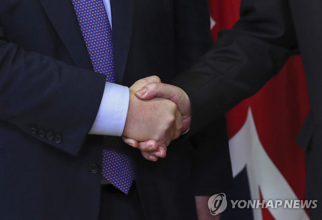 악수하는 융커 EU 집행위원장과 존슨 영국 총리