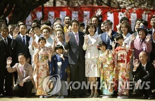 아베 신조 총리가 올해 4월 13일 도쿄 도심 공원인 '신주쿠 교엔'에서 열린 '벚꽃을 보는 모임' 행사에서 참석자들과 기념사진을 찍고 있다.