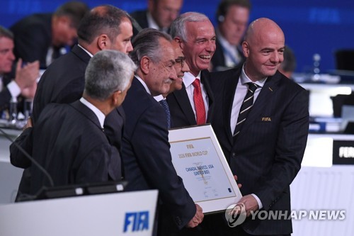 13일(한국시간) 러시아 모스크바 엑스포센터에서 제68차 FIFA 총회에서 2026년 월드컵 개최지로 결정된 북중미 3개국 연합 대표단이 잔니 인판티노(맨오른쪽) 회장과 개최지 증서를 들고 기념사진을 찍고 있다.(AFP=연합뉴스)