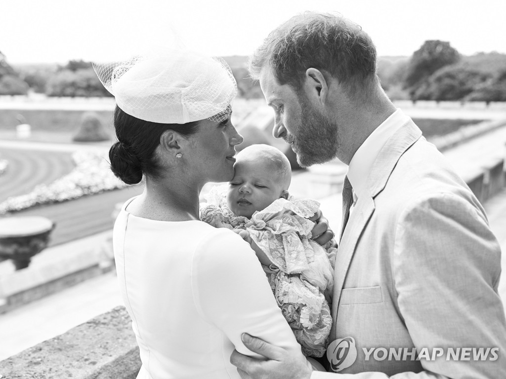 2019년 7월 6일 영국 런던 윈저성 장미정원에서 영국 해리 왕자와 부인 메건 마클이 이날 성공회 세례를 받은 첫 아이 아치 해리스 마운트배튼-윈저를 안고 있다. [AFP=연합뉴스]