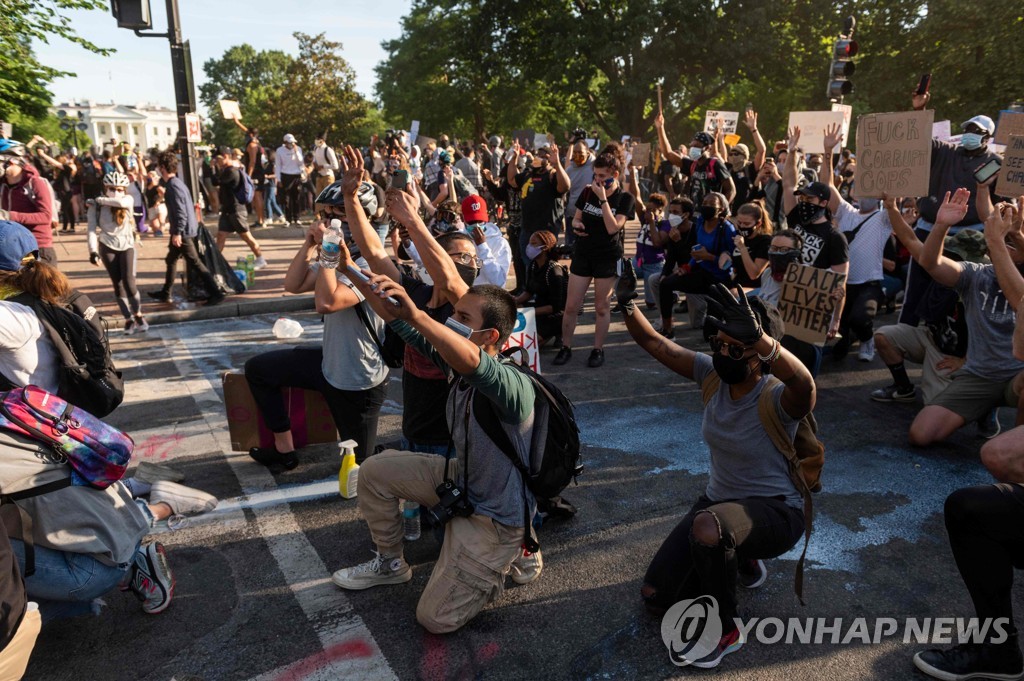 백악관 앞에서 경찰 앞에서 무릎 꿇고 손을 들어 시위하는 군중 [AFP=연합뉴스] 
