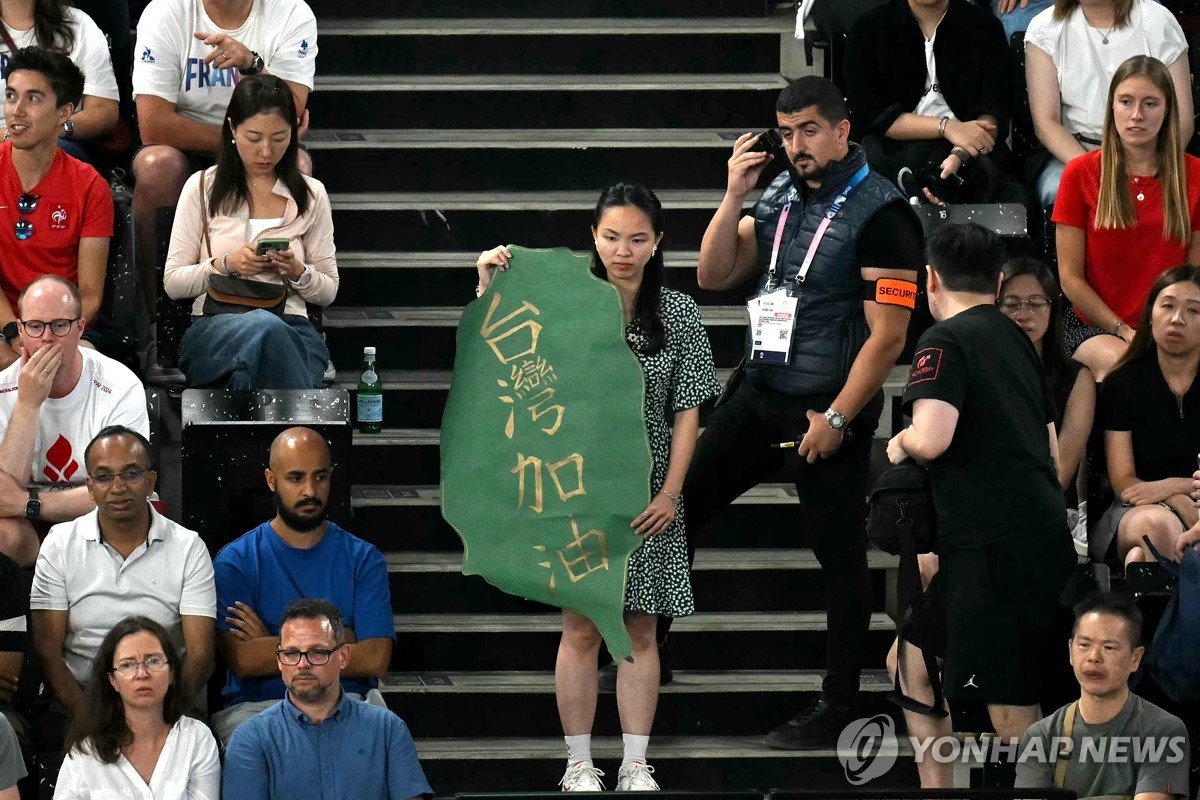 대만 응원 배너를 든 관중 옆에서 경호 요원이 무선 지시를 받는 모습.