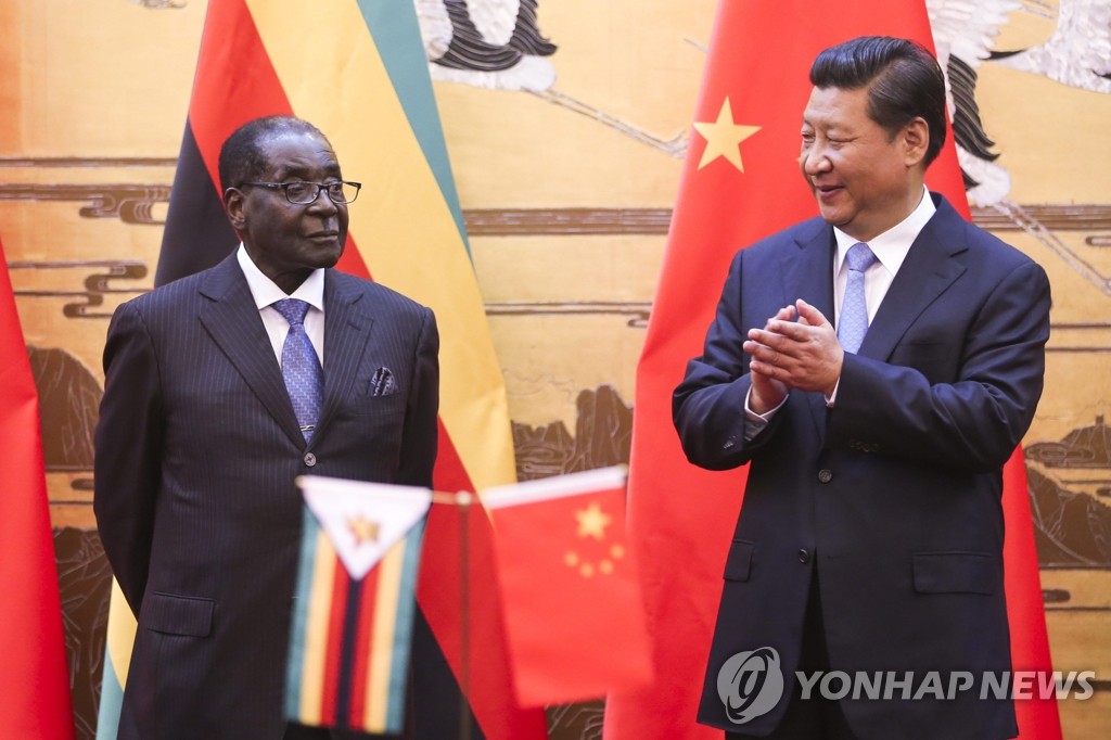 25일 중국을 방문중인 로버트 무가베 짐바브웨 대통령(왼쪽)이 시진핑(習近平) 국가주석과 대화를 나누고 있다. (EPA=연합뉴스)