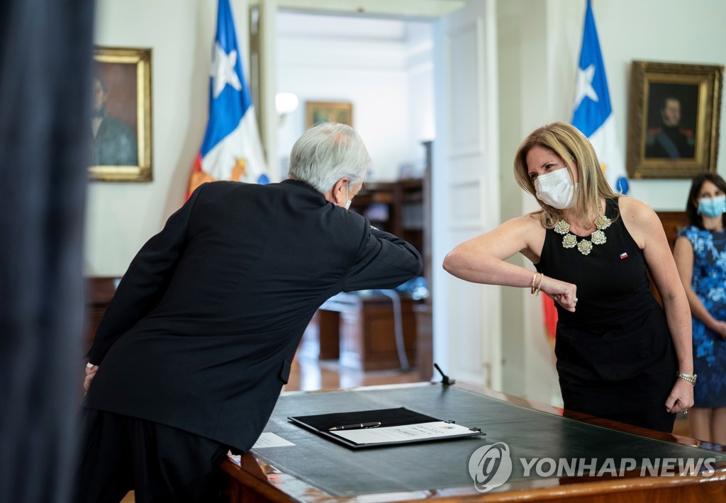 취임 전 피녜라 칠레 대통령과 팔꿈치 인사하는 산텔리세스 새 여성장관(오른쪽)