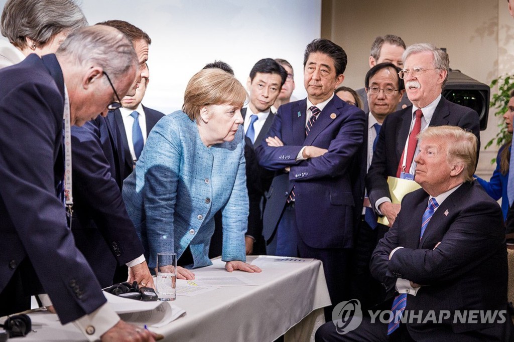 작년 캐나다 G7 정상회담에서 심각한 표정으로 대화하는 G7 정상들과 보좌진들. 팔짱을 끼고 앉아있는 도널드 트럼프 미국 대통령(오른쪽 아래)과 탁자에 손을 짚고 트럼프에게 무언가를 말하고 있는 앙겔라 메르켈 독일 총리(가운데 여성)의 표정이 이채롭다. [독일연방정부 트위터·UPI=연합뉴스 자료사진]