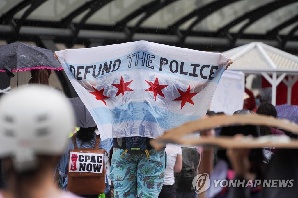 시위 중 '경찰 예산을 끊어라'(DEFUND THE POLICE)는 내용의 플래카드를 걸치고 있는 모습
