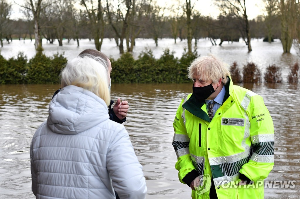 21일(현지시간) 영국 맨체스터 홍수 피해현장을 찾은 보리스 존슨 총리가 주민과 대화하고 있다. [로이터=연합뉴스]