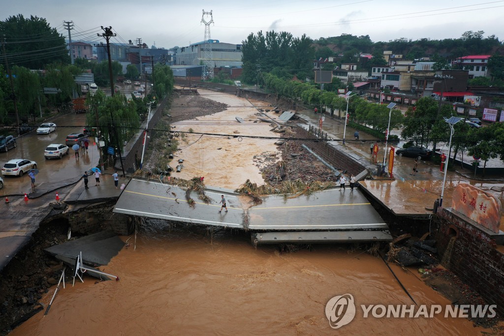 21일 허난성 궁이에서 폭우로 파손된 다리 위로 주민들이 걷고 있다. [로이터=연합뉴스]