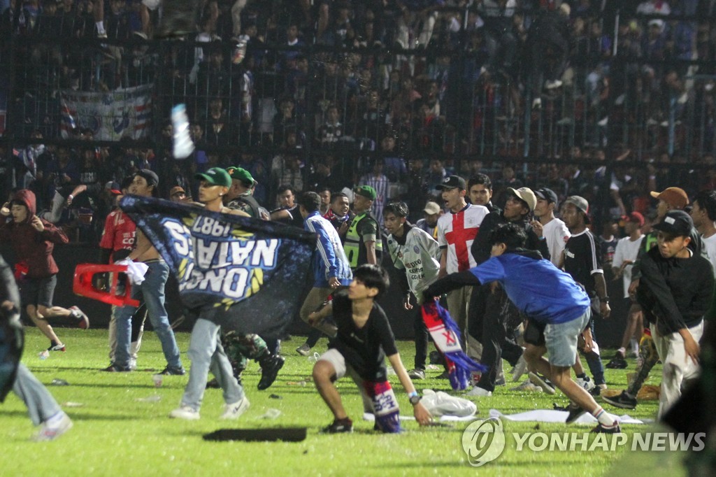 In this Reuters photo, Arema FC supporters enter the field after the team they support lost to Persebaya after the league BRI Liga 1 football match at Kanjuruhan Stadium, Malang, East Java province, Indonesia, October 2, 2022. (Yonhap)