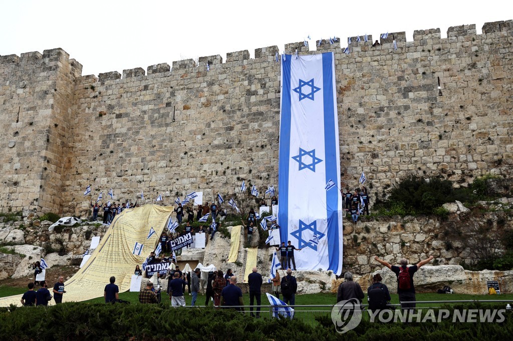예루살렘 성지 벽에 이스라엘 국기와 독립 선언문을 내걸고 사법 개혁 반대 시위를 벌이는 시민들.