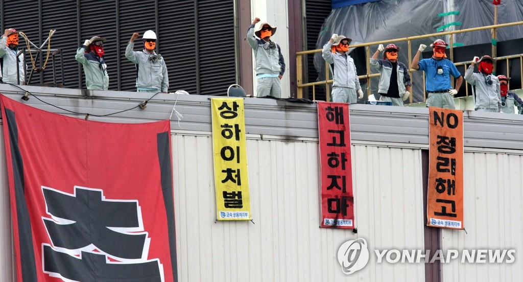 지난 2009년 7월 23일 경기도 평택 쌍용자동차 평택공장에서 경찰과 대치 중인 쌍용차 노조원들이 도장공장 옥상에서 구호를 외치고 있다. <<연합뉴스DB>>