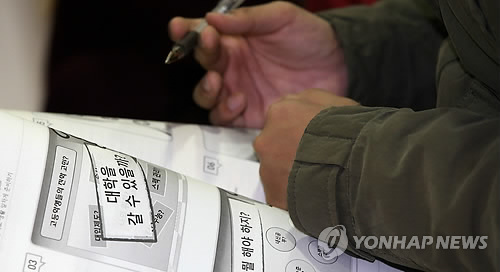 2015학년도 학생부 전형에 활용되는 자기소개서와 교사추천서에 외부 스펙을 기재하면 서류전형 점수가 0점 처리된다. 사진은 경기도의 한 고등학교에서 열린 대입설명회에서 교육청 자료를 살펴보는 학생의 모습.