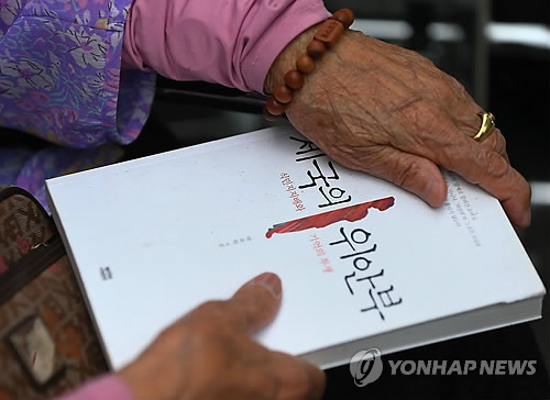 제국의 위안부 책 들고 있는 군위안부 피해자