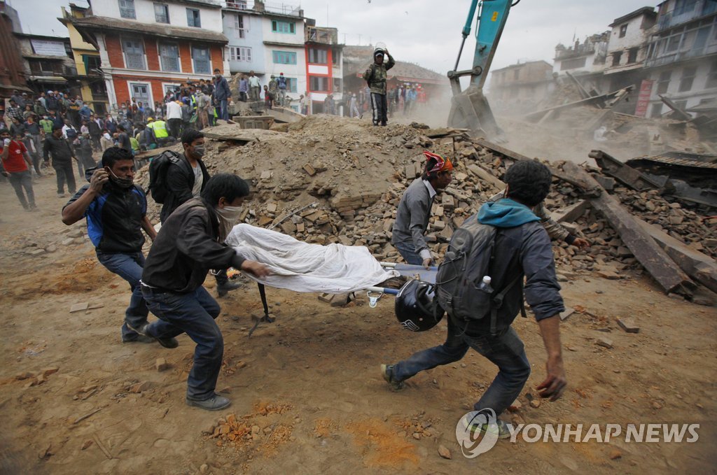 정부는 대지진이 발생한 네팔 긴급 구호지원을 검토하고 있다. 사진은 네팔을 카트만두의 건물 붕괴 현장에서 발굴된 사망자의 시신을 자원봉사자들이 옮기고 있는 모습. AP=연합뉴스) 
