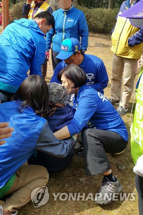 유세 현장서 쓰러진 70대女 응급조치하는 우윤근 후보 부인