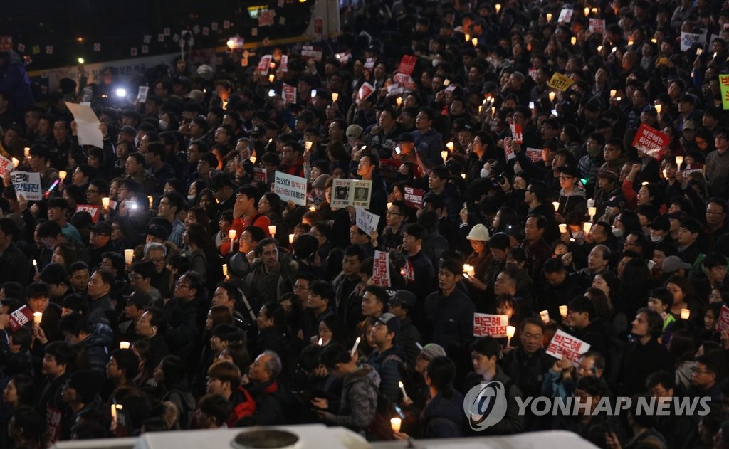 지난 19일 열린 박근혜 대통령 퇴진 촉구 촛불집회에 참가한 시민둘이 청와대 방향인 종로구 내자동로터리에서 경찰과 대치하고 있는 모습