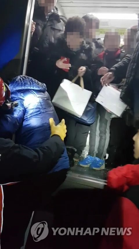 멈춰선 전동차서 탈출하는 승객