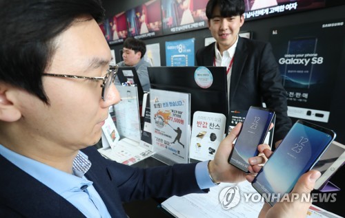 스마트폰을 살펴보는 시민(자료)
