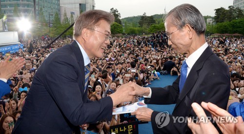 (고양=연합뉴스) 배재만 기자 = 더불어민주당 문재인 대선 후보(왼쪽)가 4일 오후 경기 고양시 일산 문화광장에서 열린 집중유세에서 한승헌 전 감사원장에게 통합정부추진위 제안서를 전달받고 있다. 2017.5.4 scoop@yna.co.kr