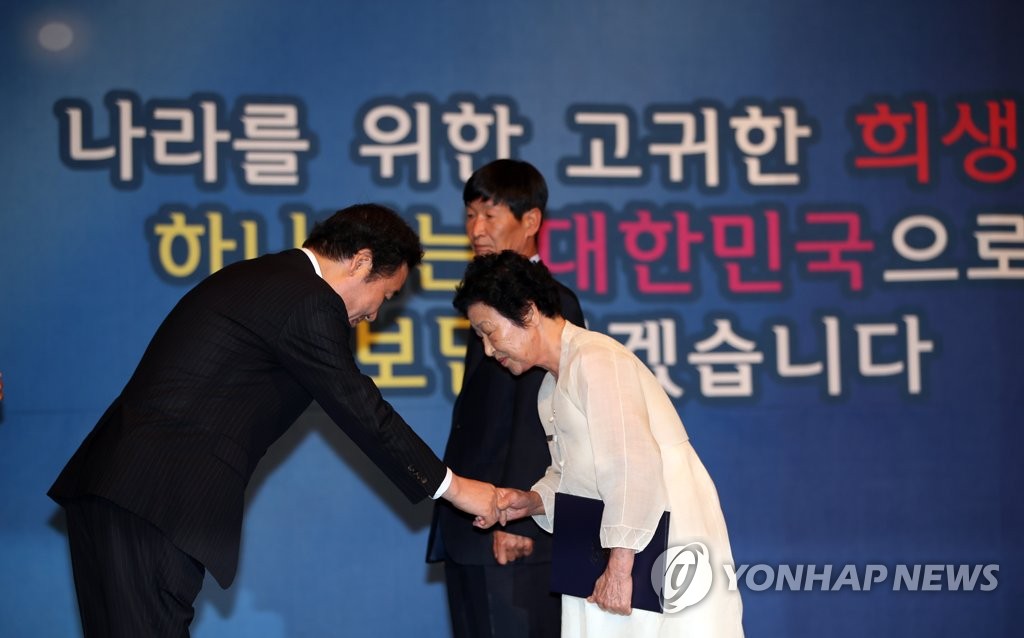 호국보훈의 달 표어 앞에서 포상하는 이낙연 총리