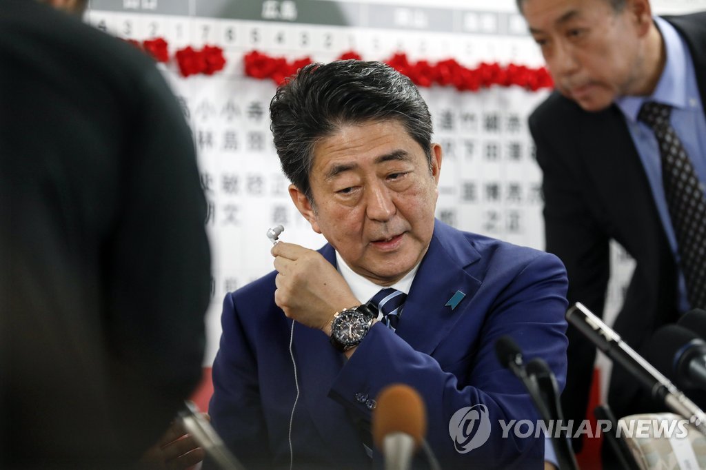 지난 2017년 중의원 선거 당시 도쿄 자민당사에서 이어폰을 빼는 아베 신조 일본 총리의 모습.[EPA=연합뉴스 자료사진]