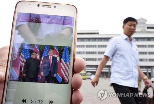 스마트폰으로 북미정상회담 뉴스 보는 평양 시민
