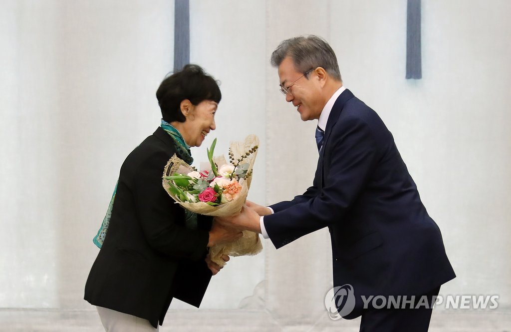 President Moon Jae-in hands a bouquet of flowers to new National Human Rights Commission chief Choi Young-ae during her appointment ceremony on Sept. 4, 2018. (Yonhap)