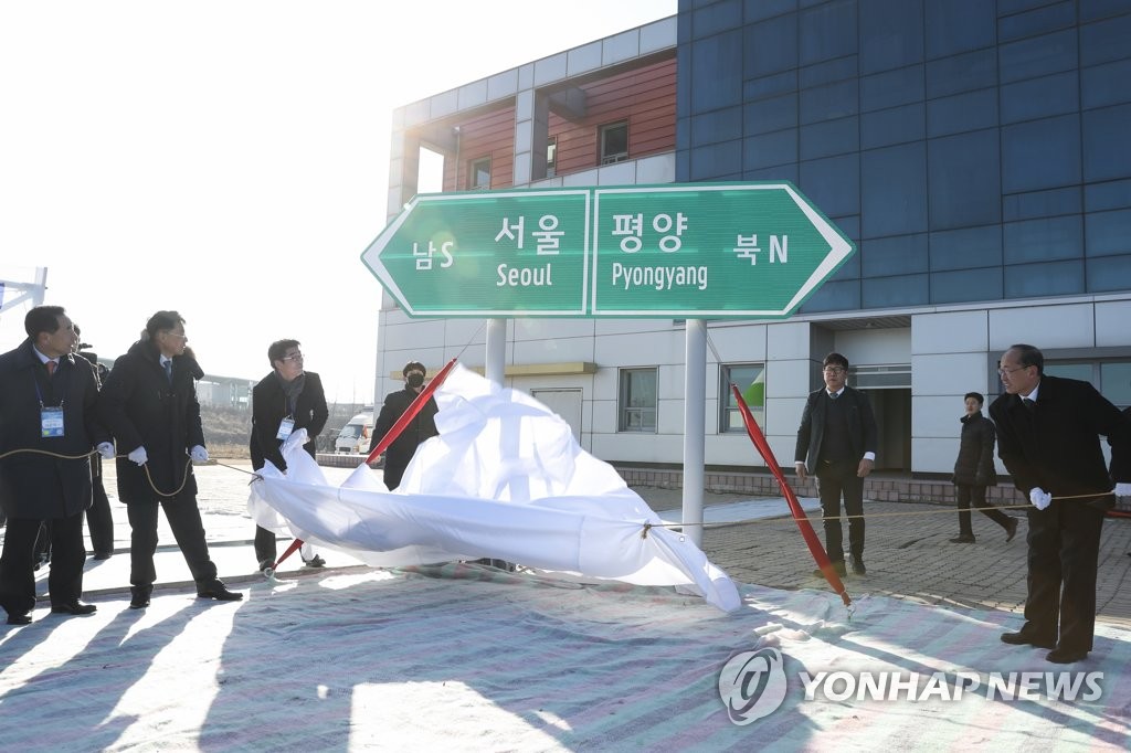 Participants unveil a road sign during a groundbreaking ceremony for a project to modernize and connect roads and railways over the border between the Koreas at Panmun Station in the North's border town of Kaesong on Dec. 26, 2018, in this photo provided by the ministry. (PHOTO NOT FOR SALE) (Yonhap)
