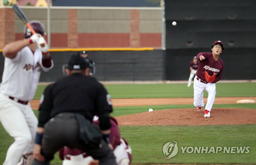Hur Min (R), chairman of the board of directors for the Kiwoom Heroes baseball club, throws a pitch in a spring training intrasquad game at Peoria Sports Complex in Peoria, Arizona, on Feb. 17, 2019. (Yonhap)