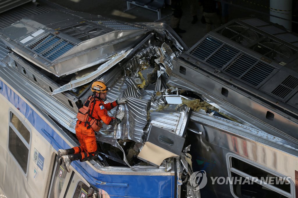 브라질 열차사고 현장서 기관사 구출하는 소방관