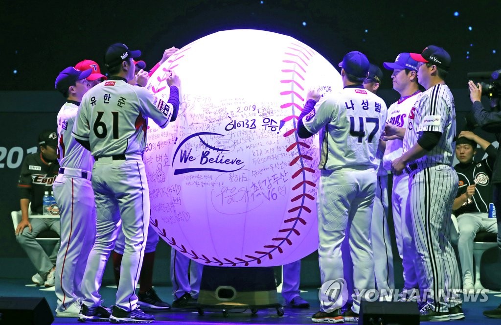 Captains of the 10 Korea Baseball Organization clubs sign a giant baseball during the annual media day in Seoul on March 21, 2019. (Yonhap)