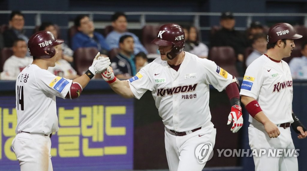 In this file photo from April 24, 2019, Jerry Sands of the Kiwoom Heroes (C) celebrates his grand slam against the Doosan Bears with teammate Seo Geon-chang (L) in the bottom of the seventh inning of a Korea Baseball Organization regular season game at Gocheok Sky Dome in Seoul. (Yonhap)