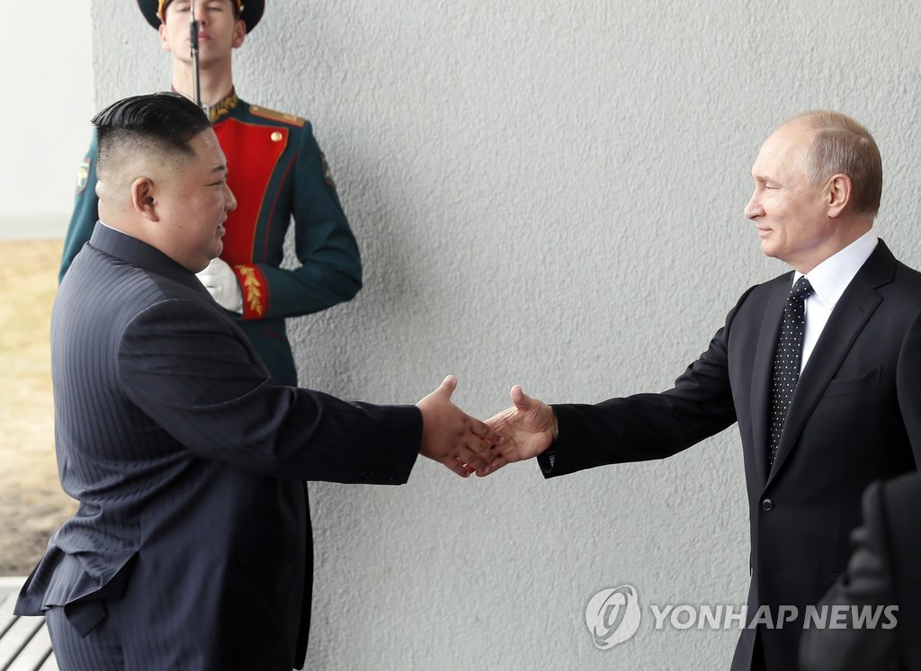 握手を交わす金委員長（左）とプーチン大統領＝（ＡＰ＝聯合ニュース）
