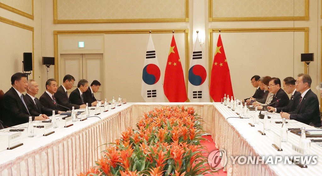 South Korean President Moon Jae-in (R) and Chinese President Xi Jinping hold talks, joined by their aides, at an Osaka hotel on June 27, 2019. (Yonhap)
