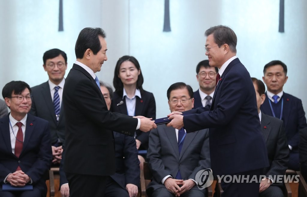 President Moon Jae-in (R) hands a letter of appointment over to Prime Minister Chung Sye-kyun during a Cheong Wa Dae ceremony on Jan. 14, 2020. (Yonhap)