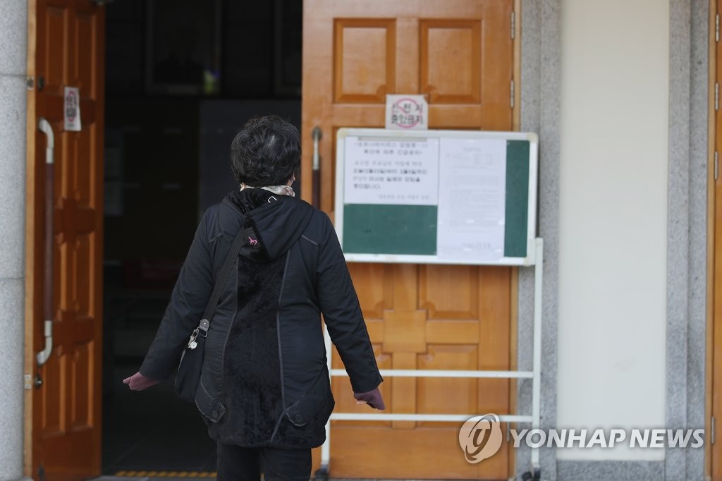 미사 중단 안내문 살펴보는 천주교 신도