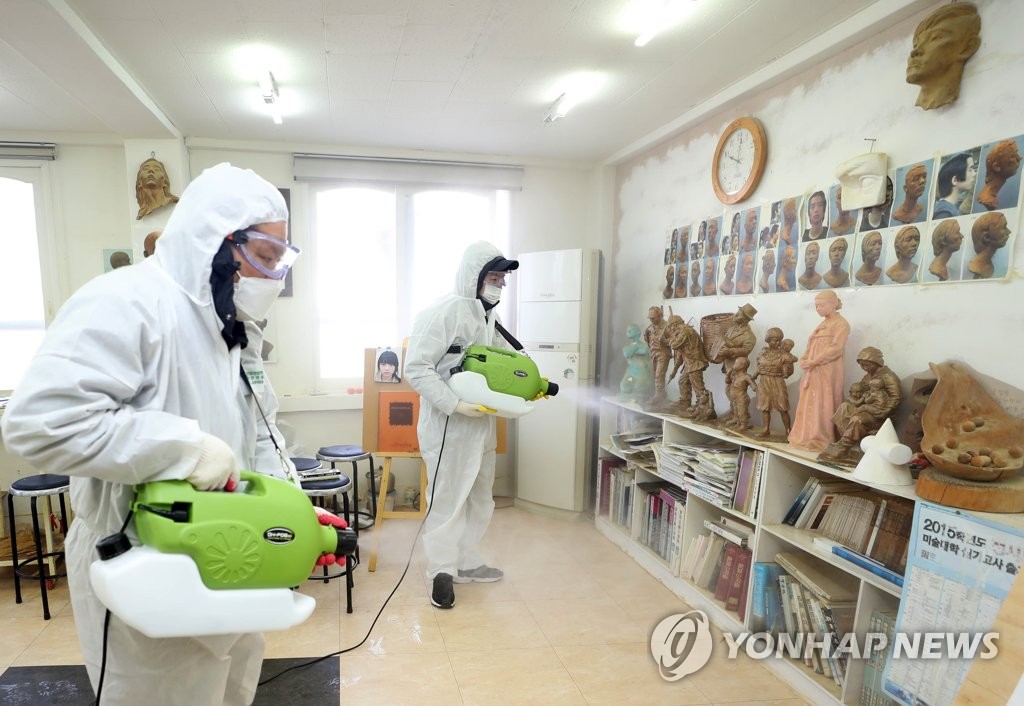 Health workers disinfect a private sector art class in the southern port city of Busan on March 6, 2020. (Yonhap)