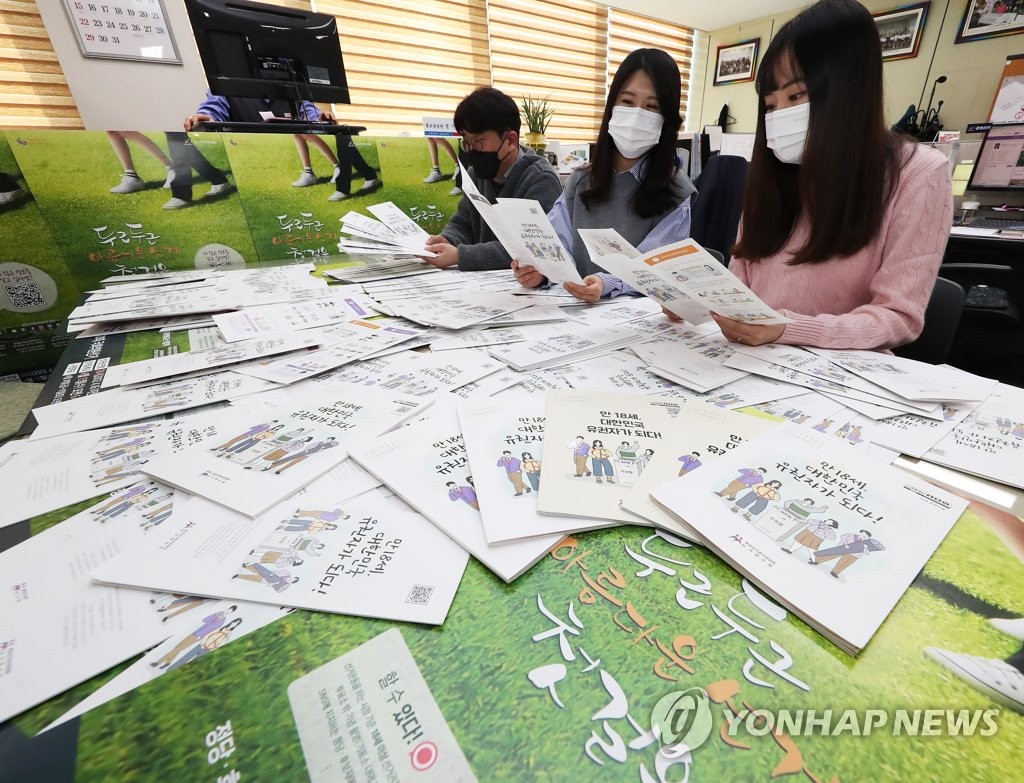 Officials at the National Election Commission look at election education materials for 18-year-old high school student voters in Suwon, south of Seoul, on March 24, 2020. (Yonhap)