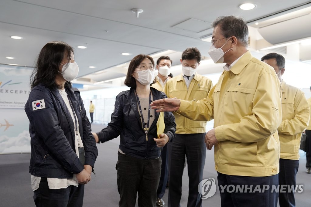 President Moon Jae-in (R) talks with a quarantine official at Incheon International Airport, west of Seoul, on April 7, 2020 in this photo provided by Cheong Wa Dae. (PHOTO NOT FOR SALE) (Yonhap)