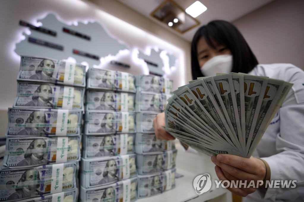 In this file photo, taken on May 6, 2020, a Hana Bank official in Seoul is seen inspecting U.S. banknotes before their release into the local financial market. (Yonhap)