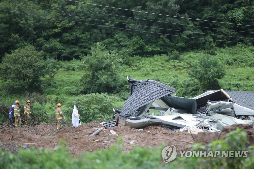 Rescue workers search for a person trapped in the debris of a landslide at a village in Gokseong, about 400 kilometers south of Seoul, on Aug. 8, 2020. Four people were dead and one missing after the landslide triggered by heavy rain. (Yonhap)