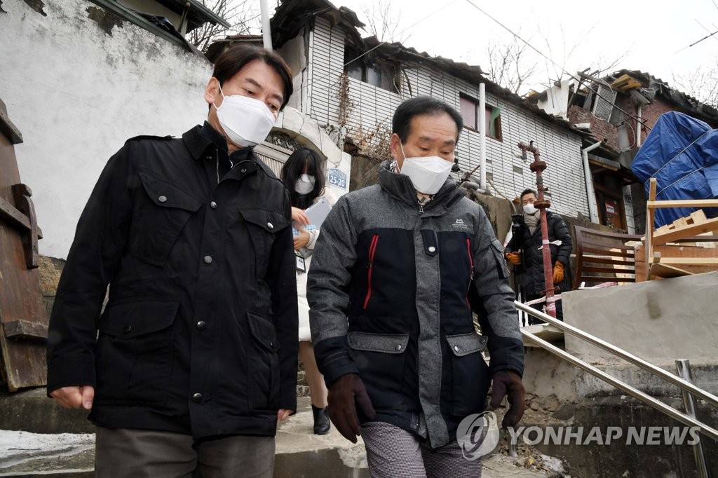 Ahn Cheol-soo (L), leader of the minor opposition People's Party, visits a Seoul neighborhood under redevelopment on Jan. 17, 2021, in this photo provided by the National Assembly's photojournalists' press corps. (Yonhap)